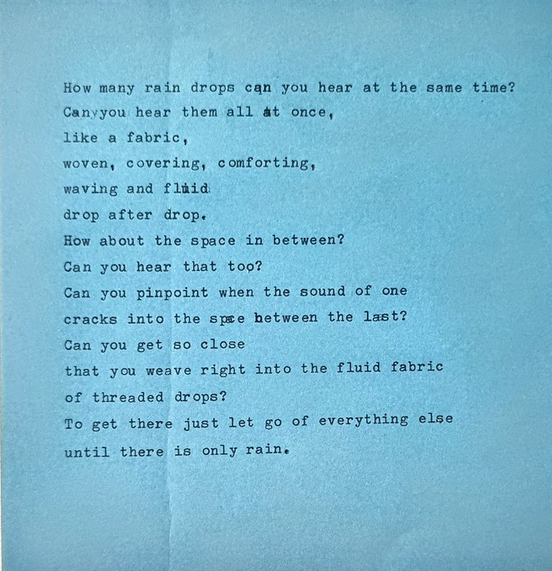 Rain — a typewritten poem on blue paper beginning 'How many rain drops can you hear at the same time?'.